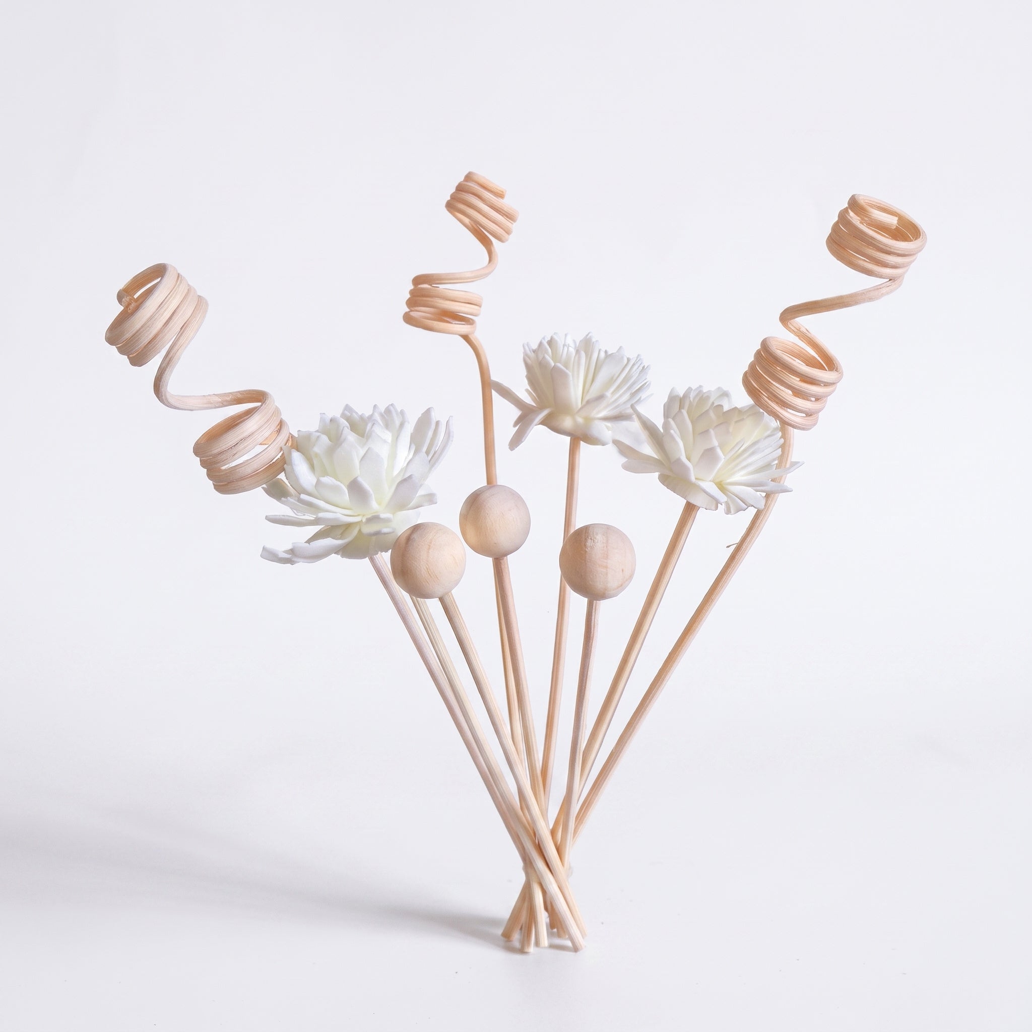 Lot de 9 tiges diffusantes blanc crème : 3 fleurs de sola, 3 perles de bois et 3 spirales en rotin, photo studio sur fond blanc