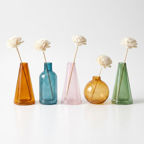 Les 5 couleurs de vase au choix dans le Cocon Découverte : cône ambré, flacon bleu canard, cône rosé, sphère miel, fiole verte